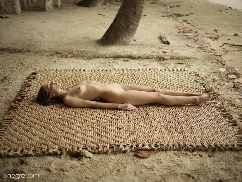 Раздетая худощавая проститутка позирует на пляже